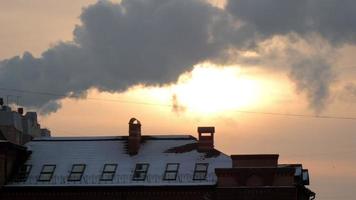 Winter cold sunset above city buildings roof video