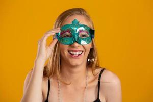 hermosa mujer vestida para la noche de carnaval. mujer sonriente lista para disfrutar del carnaval con una máscara colorida. foto