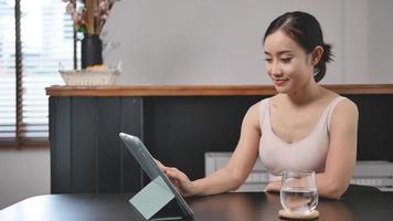 Alleinstehende Frauen trainieren, schauen online fern, sitzen zu Hause auf dem Sofa im Wohnzimmer. video