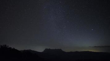 noite estrelada sobre lapso de tempo de montanha de estrelas no céu noturno escuro. video