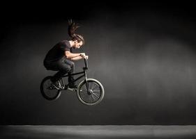 joven haciendo un truco en su bicicleta bmx. foto