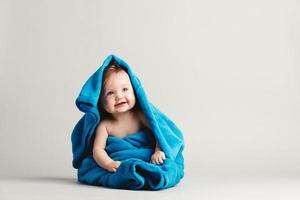 Baby girl covered with a blue warm blanket photo