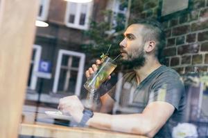 Man drinking cold fit beverage in a cafe. photo