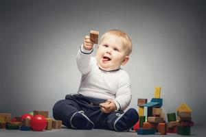 Little boy handing a wooden brick. photo