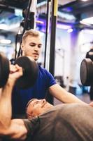 Personal trainer instructing older man during exercise. photo