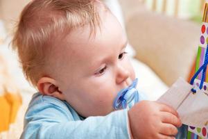 Young baby boy with a dummy in his mouth photo