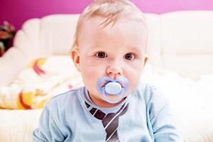 Young baby boy with a dummy in his mouth portrait photo