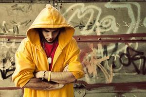 Poland, 2022 - Young man in hooded sweatshirt on grunge wall photo