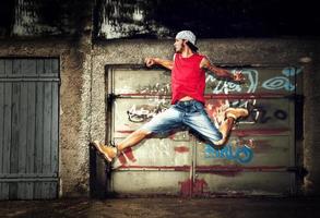 Poland, 2022 - Young man jumping on grunge wall photo