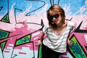 Poland, 2022 - Stylish girl in a dance pose against graffiti wall photo