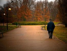 Old aged man walks in park photo