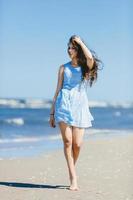 Young girl casually walking on a coast photo