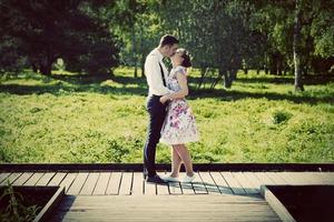 Young couple in love standing on wooden cross-roads photo