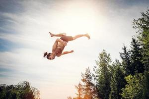 Young man jumping high in the sky. photo