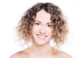 joven mujer sonriente con retrato de pelo rizado en blanco foto