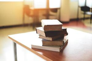 Books on the table in the library - Education learning book stack on wood desk and blurred room background, back to school concept photo