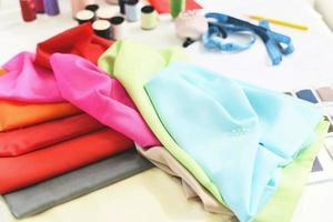 herramientas hilo de coser artesanal e hilo de aguja para diseñador de moda en estudio material textil tijeras corte tela ropa máquina de coser diseñador trabajando profesional tela de colores foto