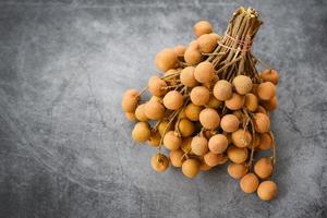 dimocarpus longan frutas exóticas sobre fondo negro - racimo de fruta tropical longan fresca en tailandia foto