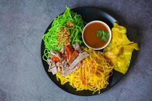 fideos de jade y fideos amarillos comida asiática de Tailandia, pato asado con fideos de jade y albóndigas de cerdo en un plato y salsa de pato, fideos verdes comida china foto