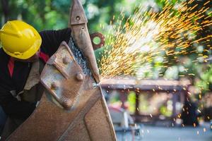Los trabajadores metalúrgicos utilizan mano de obra manual, herramientas de corte de acero para cortar acero. cortar metales molienda de acero en una fábrica. foto
