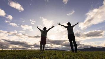 little boy with his mother Raise your hand to pray for God's blessing in the morning on the mountain with Christian concept copy space. photo