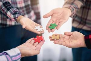 A group of business people assembling jigsaw puzzle.  Successful teamwork in finding business solutions.The concept of cooperation,  help and support in business. photo