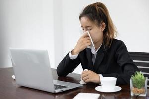 Tired asia business woman with headache at office, feeling sick at work, copy space photo