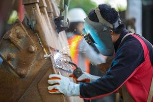 marco de construcción de soldadura de soldador especializado, chispa de soldadura, soldador es servicio de mantenimiento de construcción y fabricación de carpintería metálica de soldadura. foto