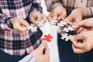 The concept of cooperation. A group of business people assembling jigsaw puzzle. teamwork, help and support in business. photo