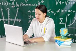 Girl writes mathematical examples on the school board. solves a geometry problem. photo