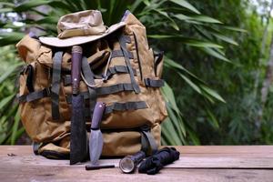 A knife with equipment for survival in the forest  on an old wooden floor photo