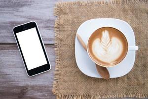 latte art coffee with smart phone with isolated screens photo