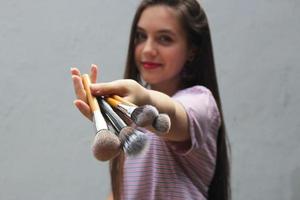 girl holding makeup brushes,makeup accessories close-up photo