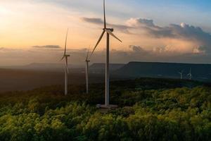 Wind energy. Wind power. Sustainable, renewable energy. Wind turbines generate electricity. Windmill farm on a mountain with sunset sky. Green technology. Renewable resource. Sustainable development. photo