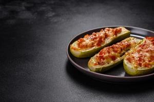 Baked stuffed zucchini boats with minced chicken mushrooms and vegetables with cheese photo