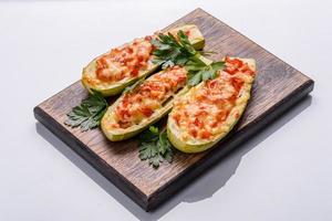 Baked stuffed zucchini boats with minced chicken mushrooms and vegetables with cheese photo