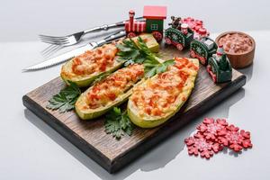 Baked stuffed zucchini boats with minced chicken mushrooms and vegetables with cheese. Christmas table photo