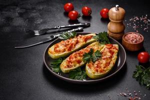 Baked stuffed zucchini boats with minced chicken mushrooms and vegetables with cheese photo