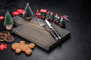 Christmas homemade gingerbread cookies, spices and cutting board on dark background photo