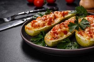 Baked stuffed zucchini boats with minced chicken mushrooms and vegetables with cheese photo