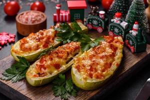 Baked stuffed zucchini boats with minced chicken mushrooms and vegetables with cheese. Christmas table photo