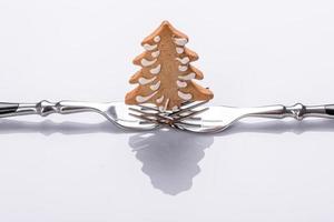 A small Christmas tree decoration on two forks on a white background photo