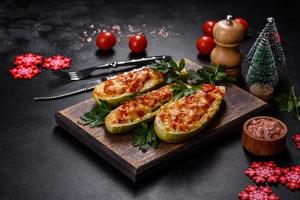 Baked stuffed zucchini boats with minced chicken mushrooms and vegetables with cheese. Christmas table photo