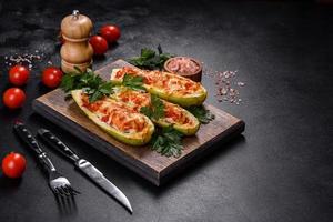 Baked stuffed zucchini boats with minced chicken mushrooms and vegetables with cheese photo