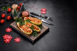 Baked stuffed zucchini boats with minced chicken mushrooms and vegetables with cheese. Christmas table photo