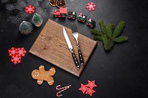 Christmas homemade gingerbread cookies, spices and cutting board on dark background photo