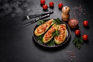 Baked stuffed zucchini boats with minced chicken mushrooms and vegetables with cheese photo