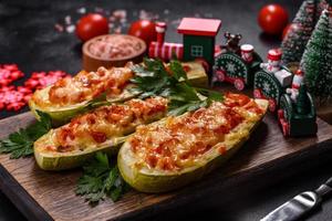 Baked stuffed zucchini boats with minced chicken mushrooms and vegetables with cheese. Christmas table photo