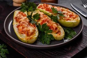 Baked stuffed zucchini boats with minced chicken mushrooms and vegetables with cheese photo