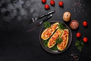 Baked stuffed zucchini boats with minced chicken mushrooms and vegetables with cheese photo